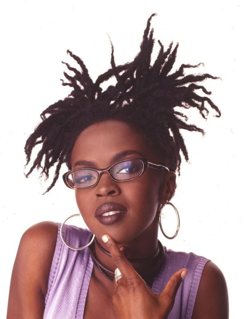 Lauryn Hill usando dreadlock, usando óculos de armação escura, argolas prateadas, maquiagem marcante e batom escuro. Veste blusa lilás sem mangas e acessórios discretos. Estilo moderno e ousado, com foco em tendências de moda dos anos 90.