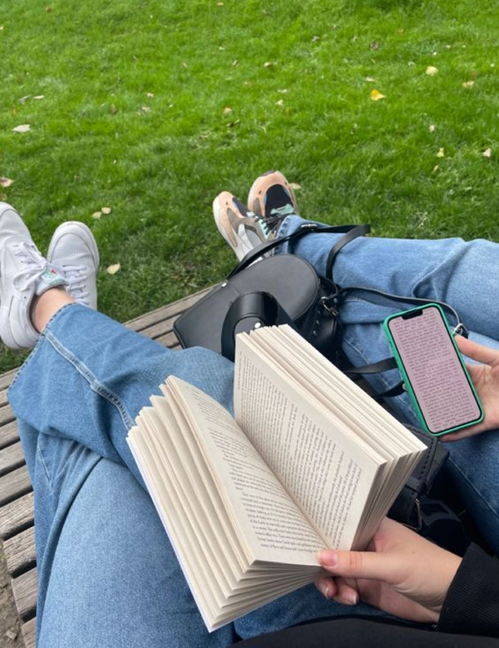 Pessoa lendo livro ao ar livre. Moda casual com tênis estilosos e calças jeans de lavagem clara. Ambiente descontraído, ideal para momentos de lazer. Linguagem do amor.