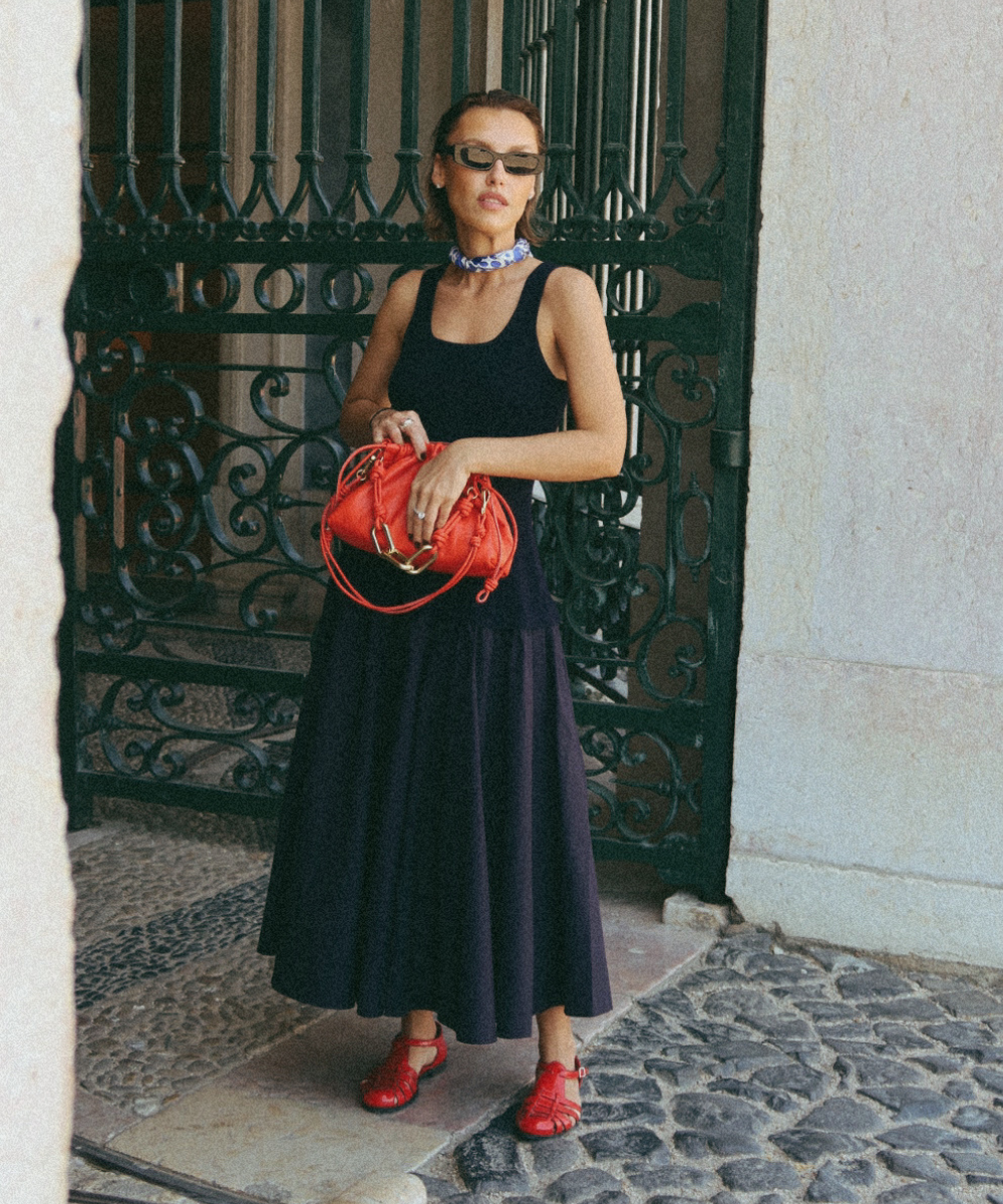 Rafaela Furlanetto usa vestido preto midi, sandália fisherman e bolsa vermelha Vicenza. Sapato tendência do verão 2025.