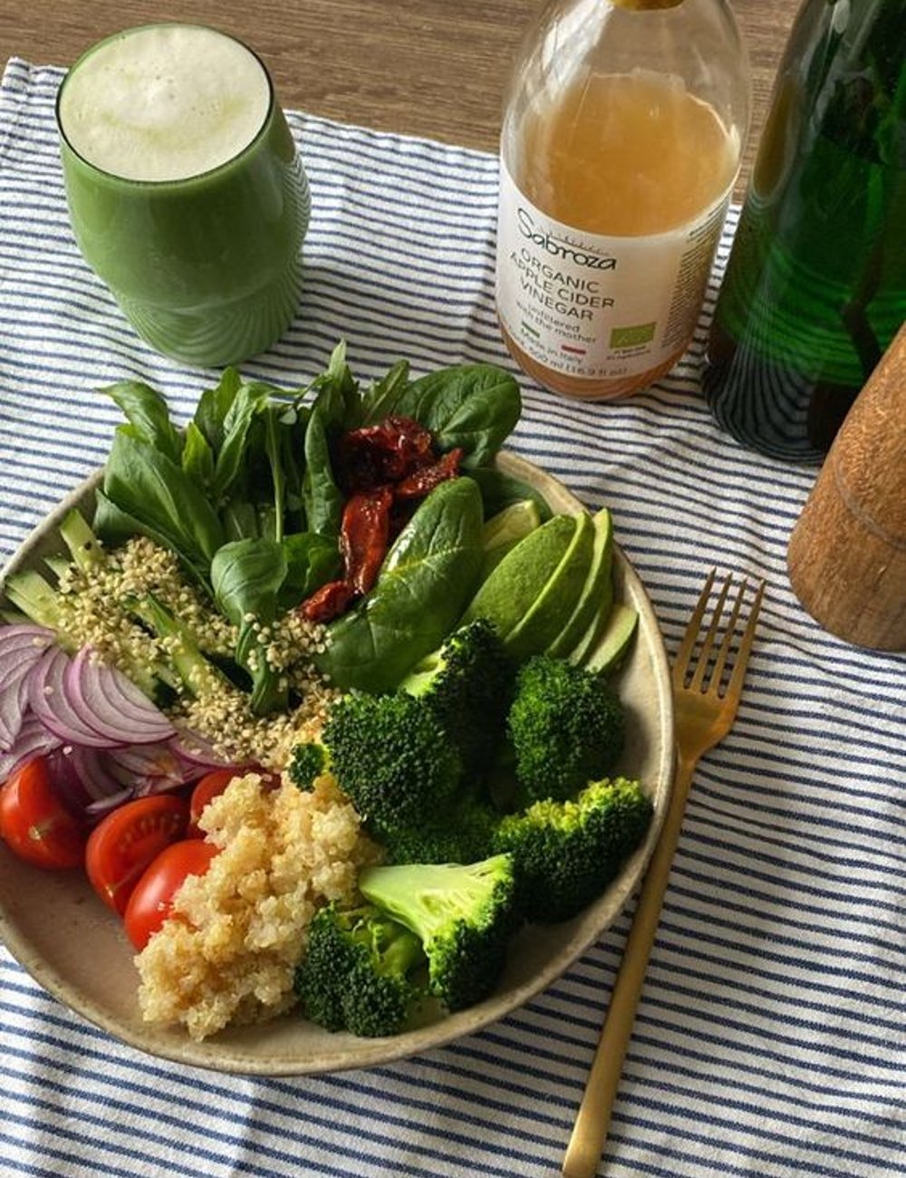 Imagem mostrando uma refeição saudável com salada de verduras, abacate, tomate, brócolis, quinoa e cebola. Acompanha um suco verde. Alimentos que melhoram a imunidade.