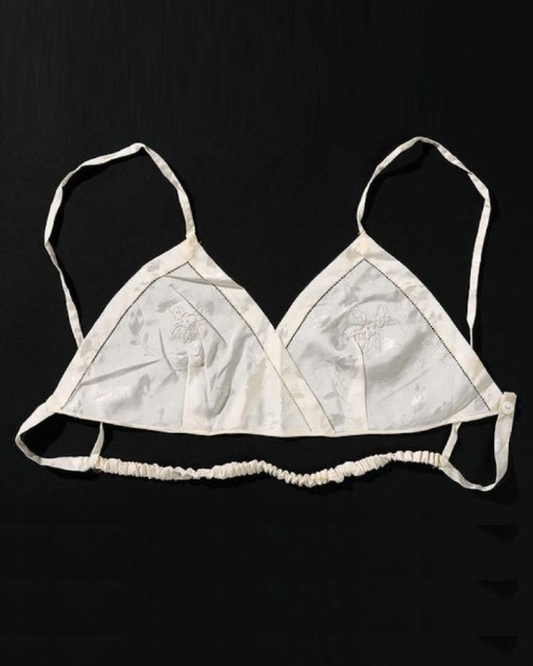 Sutiã bralette branco de cetim com alças finas, sem aro e sem bojo. Apresenta detalhes florais discretos no tecido. Estilo minimalista e confortável, perfeito para o uso diário ou para compor looks mais leves e casuais.