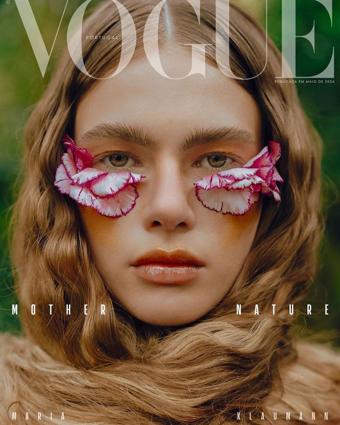 Capa da Vogue Portugal de maio de 2024 apresenta visual ousado e natural: cabelos soltos com ondas suaves, maquiagem artística com pétalas de flores ao redor dos olhos, destacando uma tendência de moda que celebra a fusão entre beleza e natureza.