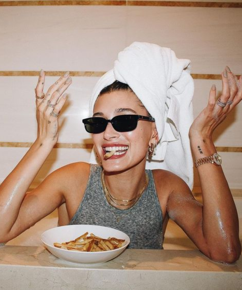 Receita de batata frita com Curry - Hailey Bieber comendo com uma toalha na cabeça.