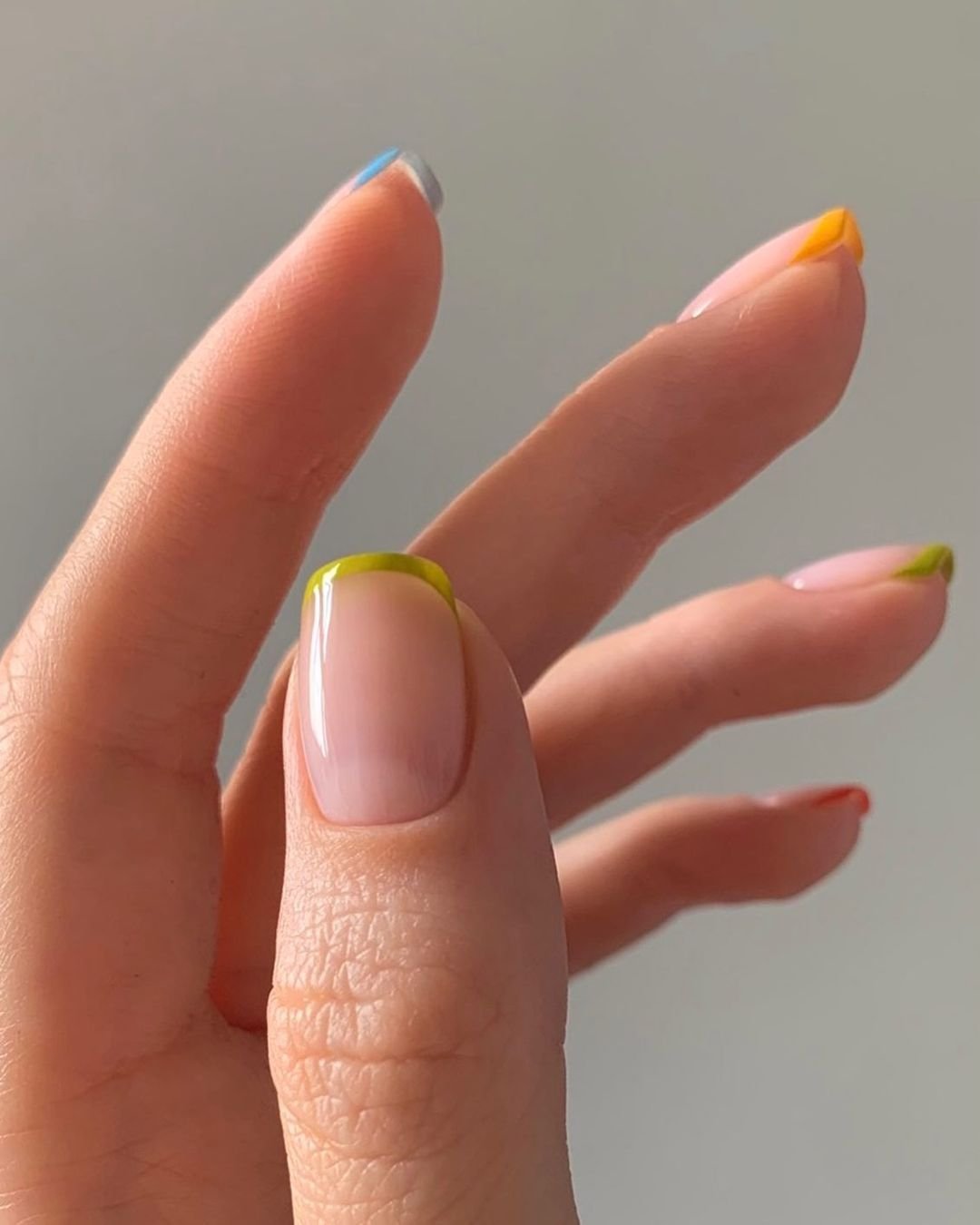 tendências de nail art decoradas com francesinha colorida em diferentes tons: azul, verde, laranja e vermelho. tendência de moda atual em nail art, adicionando um toque divertido e criativo ao estilo. Ideal para quem busca um visual moderno e ousado.