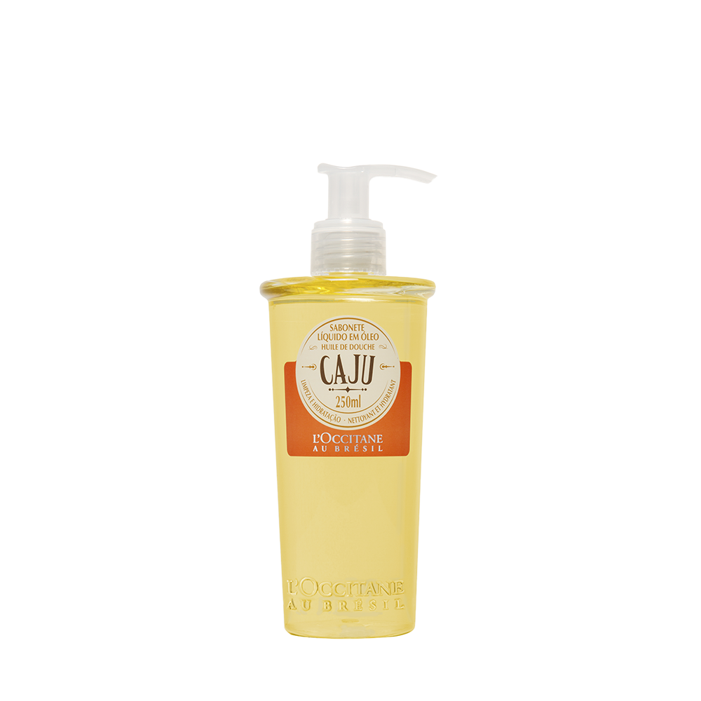 Imagem de um frasco de sabonete líquido em óleo de caju da L'Occitane au Brésil. Embalagem transparente com rótulo bege e laranja, contendo 250ml. Produto de beleza com foco em cuidados com a pele, hidratação e nutrição. cheirosa o dia todo