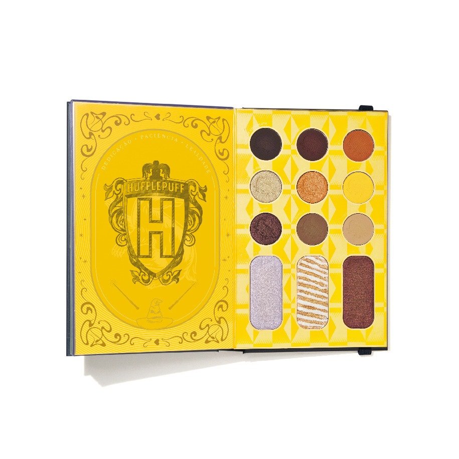 Paleta de sombras inspirada na casa Lufa-Lufa de Harry Potter. Embalagem amarela com o brasão da Lufa-Lufa e interior com sombras em tons terrosos, dourados e brilhantes. Ideal para fãs que buscam maquiagem com tema de filmes e tons versáteis.