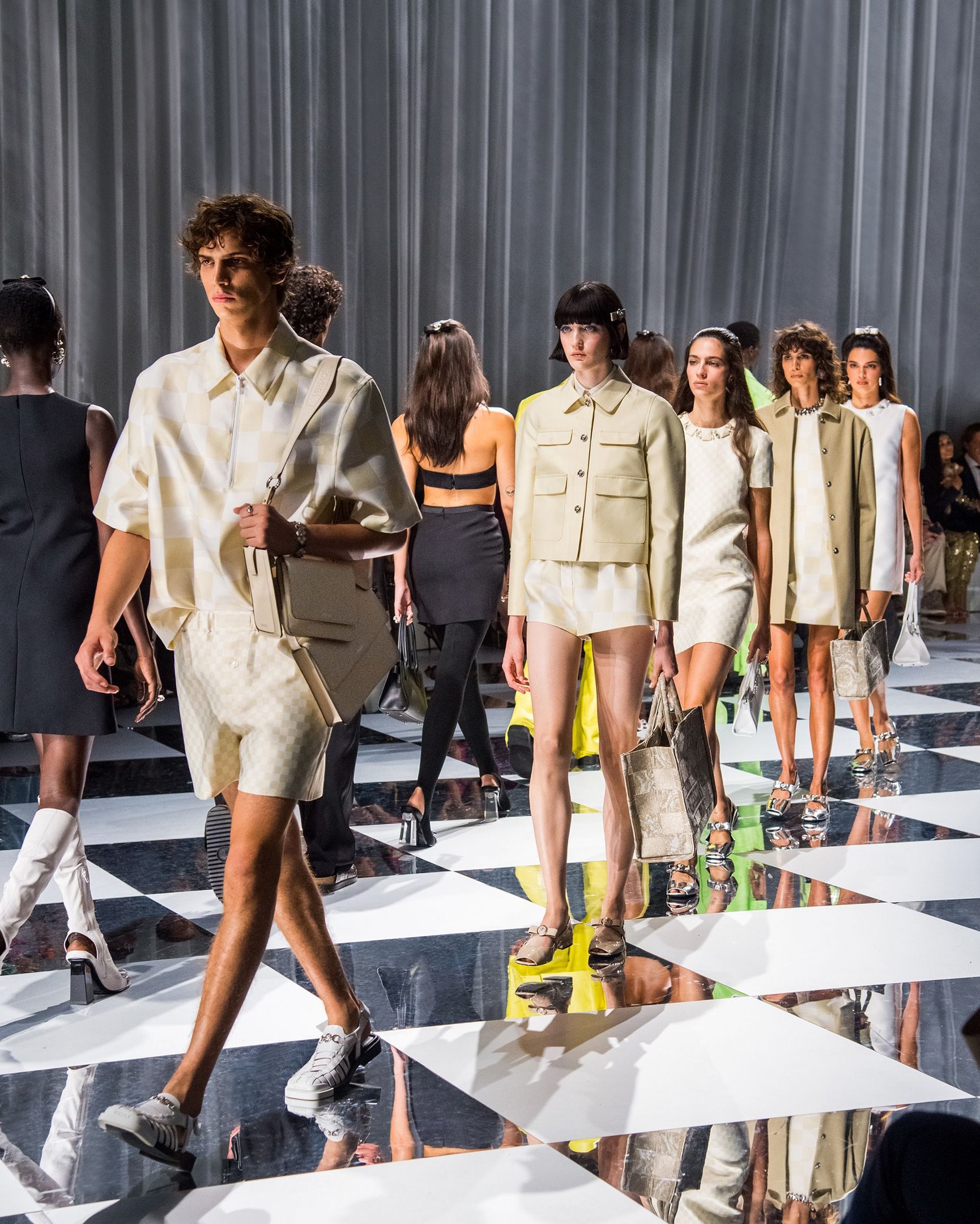 Desfile de moda com modelos vestindo roupas elegantes e modernas. Tendências incluem conjuntos com padrões geométricos, cores neutras, e cortes retos. Milão Fashion Week.