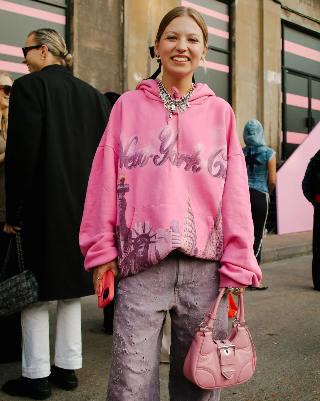 Pessoa vestida com blusa de moletom oversized rosa estampada 