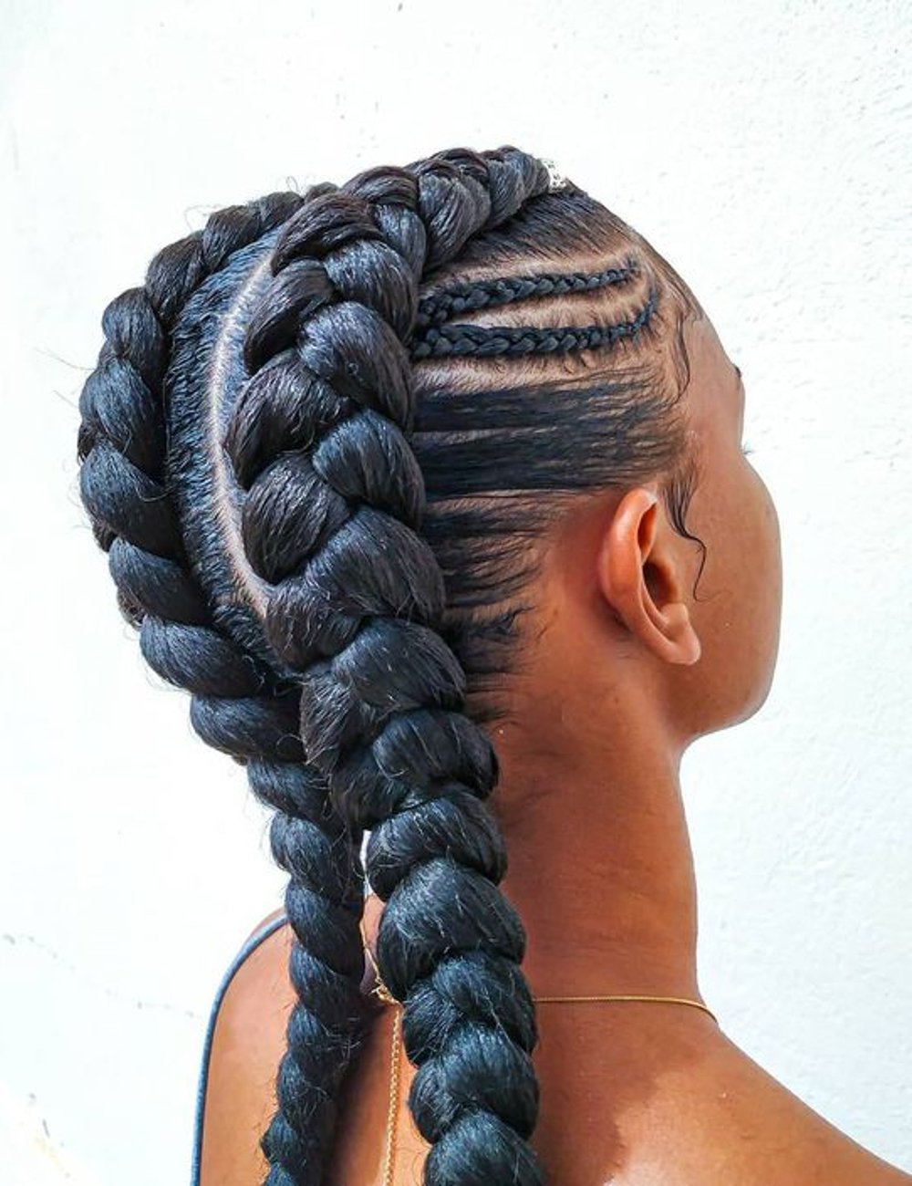 Cabelo feminino estilizado com trança boxeadora, alinhada e bem justa ao couro cabeludo, seguindo uma tendência de moda moderna e prática. Ideal para eventos casuais ou formais, este penteado destaca-se pela elegância e originalidade.