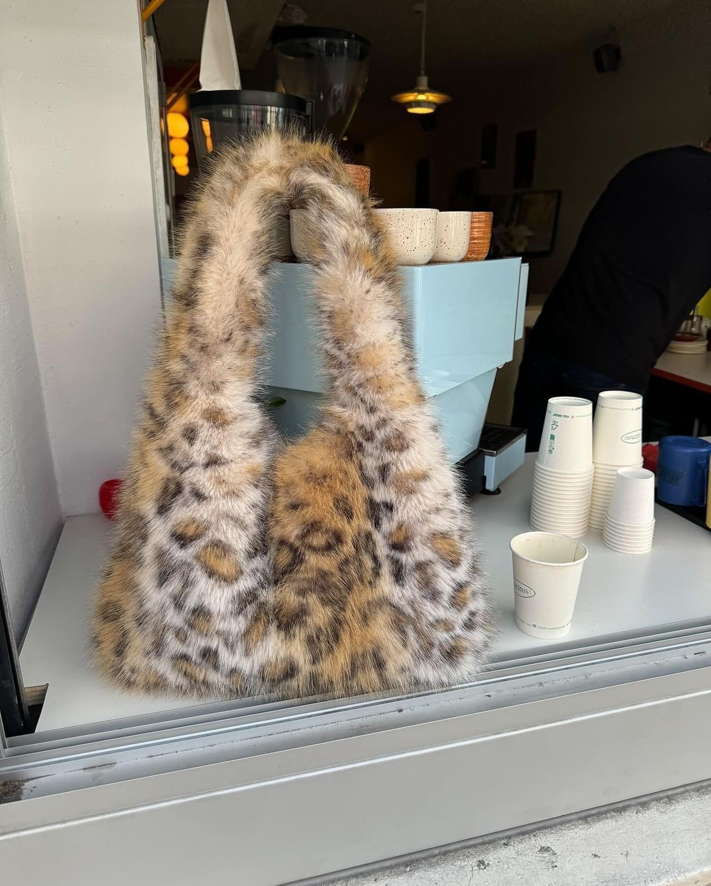 Bolsa de pelo sintético com estampa animal print em tons de marrom e branco. Acessório estiloso e versátil, ideal para compor looks modernos e despojados, seguindo a tendência atual que valoriza texturas marcantes e padrões ousados.