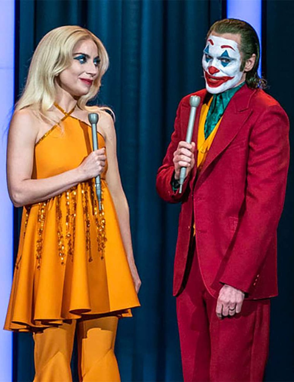 Duas pessoas fantasiadas interagem de forma expressiva. Coringa: Delírio a dois.