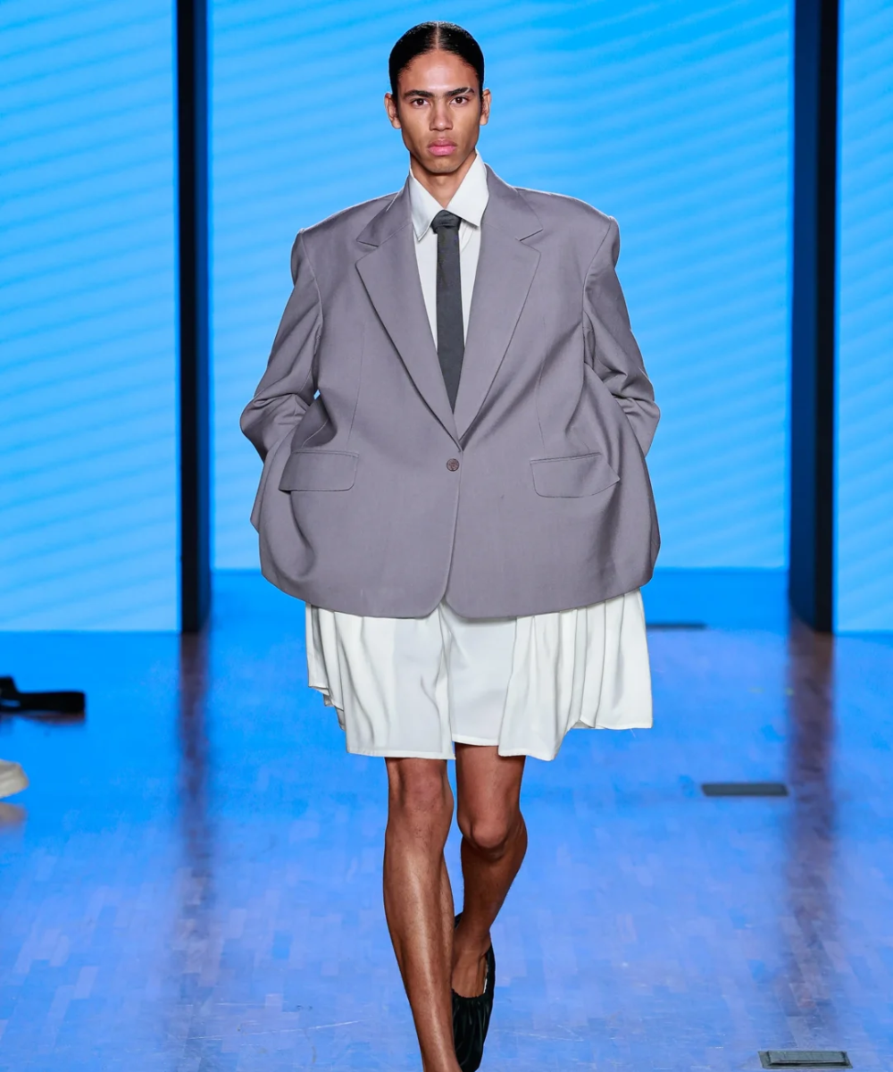 Modelo desfila com terno cinza oversized e saia branca destacando tendências do SPFW N58.