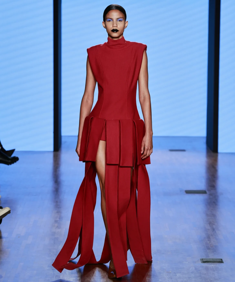 Modelo em vestido vermelho com design geométrico em desfile SPFW N58, refletindo tendências atuais.