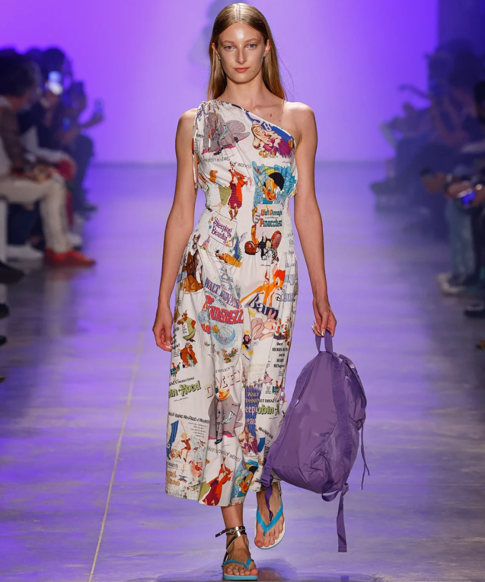 Modelo desfila com vestido estampado e mochila roxa, destacando tendências do SPFW N58.