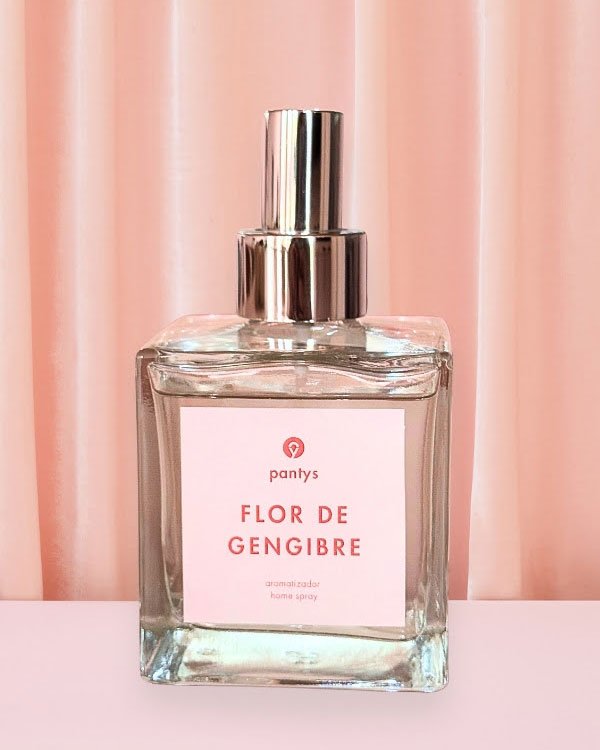 Perfume Flor de Gengibre da Pantys em frasco quadrado, fundo rosa, tampa prateada refletindo leve brilho. Home spray.