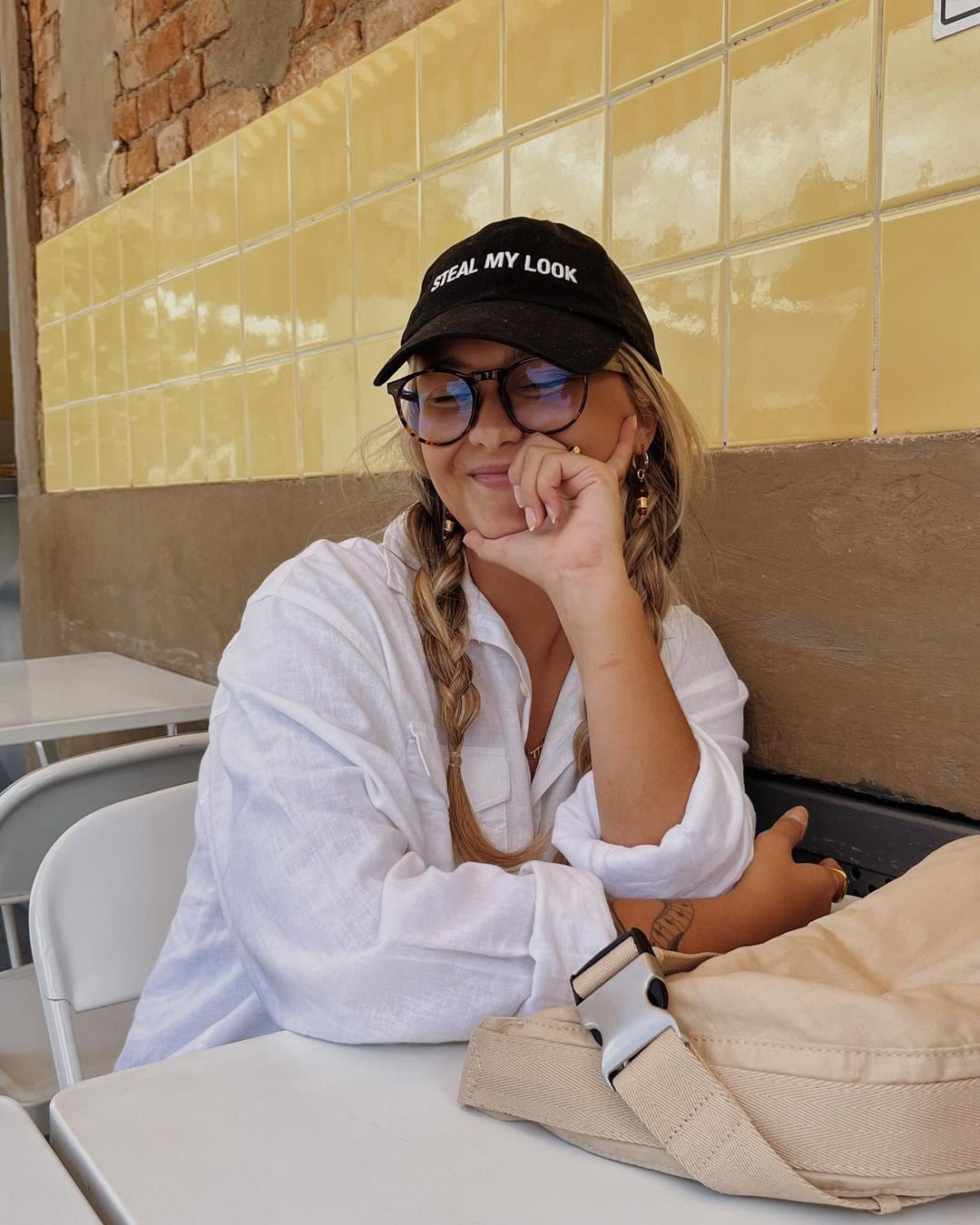 Look casual e descontraído: camisa branca oversized, boné preto com estampa 