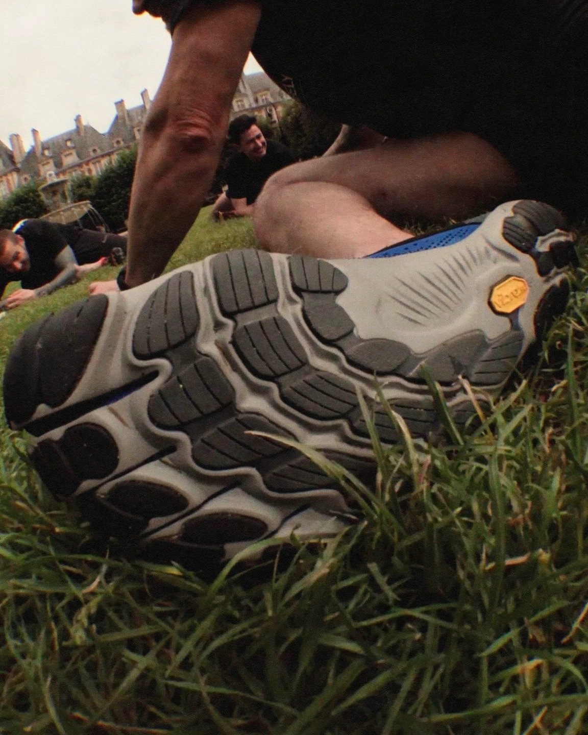 Homem usando tênis esportivo com solado robusto em atividade ao ar livre. Design casual e funcional, ideal para exercícios. Elementos contemporâneos e práticos se destacam na escolha do calçado, combinando conforto e estilo em ambiente urbano.