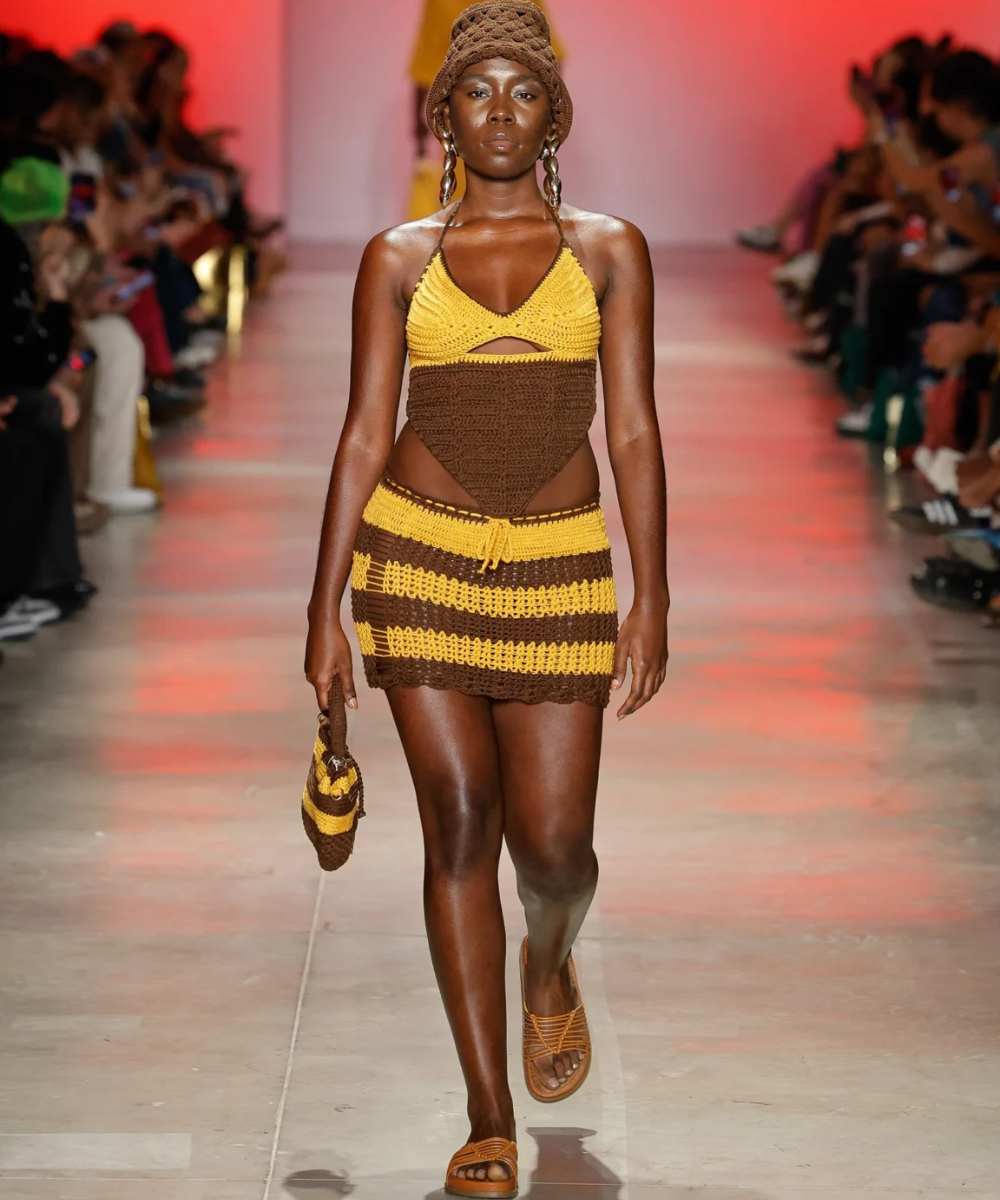 Modelo desfila look de crochê marrom e amarelo no SPFW N58, refletindo tendências de moda artesanal.