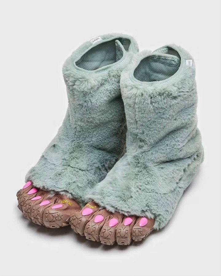 Botas peludas em verde menta com design ousado de dedos separados e solado robusto. Trazem tendência de moda excêntrica e divertida, misturando textura peluda com detalhes em rosa vibrante. Perfeitas para looks únicos e vanguardistas.