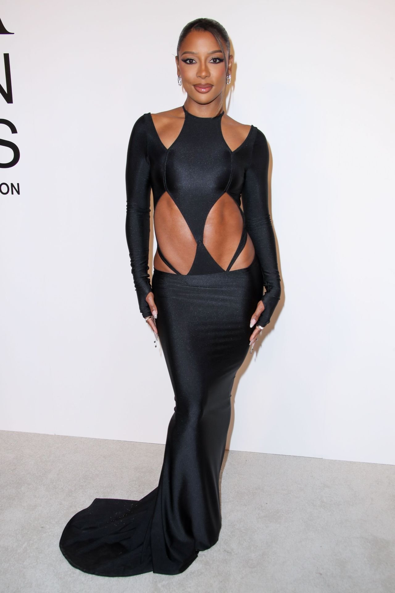 Pessoa em vestido preto estilizado no CFDA Fashion Awards 2024, destacando detalhes recortados e sofisticados.