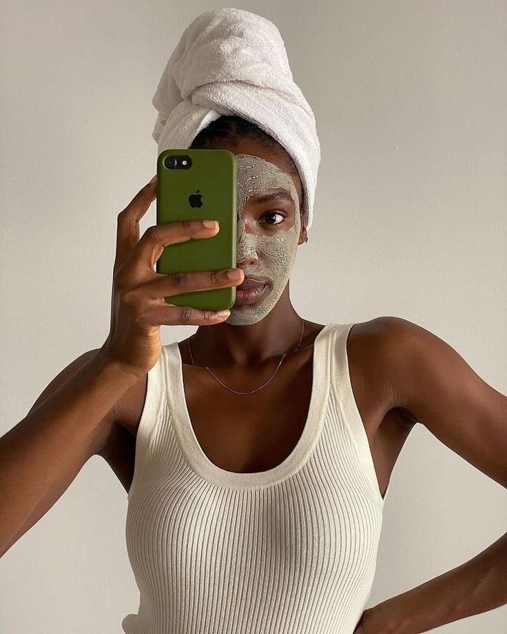 mulher negra fazendo skincare em selfie no espelho - descontos de Black Friday de moda e beleza