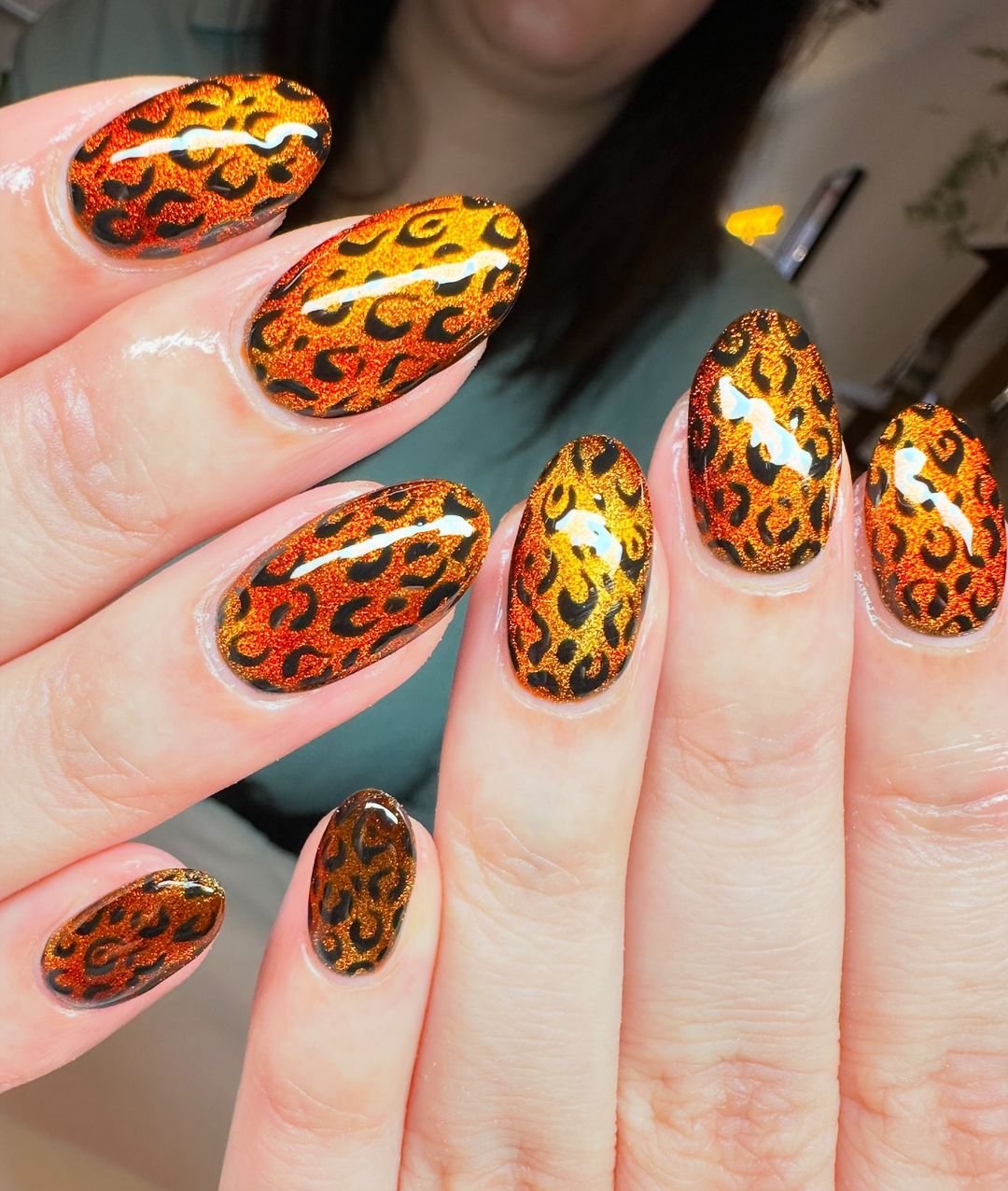 Unhas com estampa flamejante em laranja e preto, seguindo as tendências de unhas 2025.