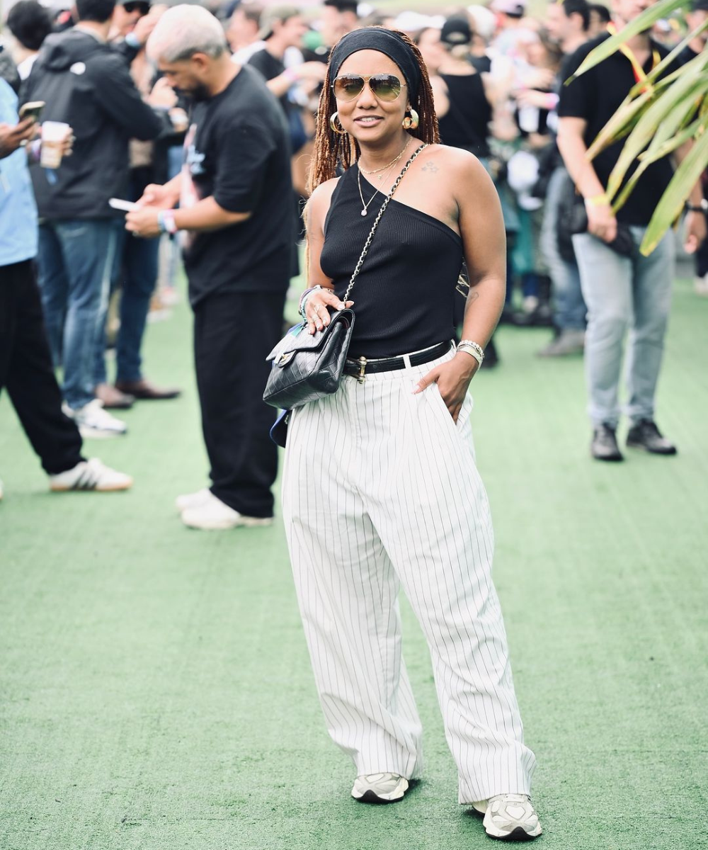 Pessoa com óculos de sol e roupa casual em evento do GP de São Paulo 2024, cercada por outras pessoas.