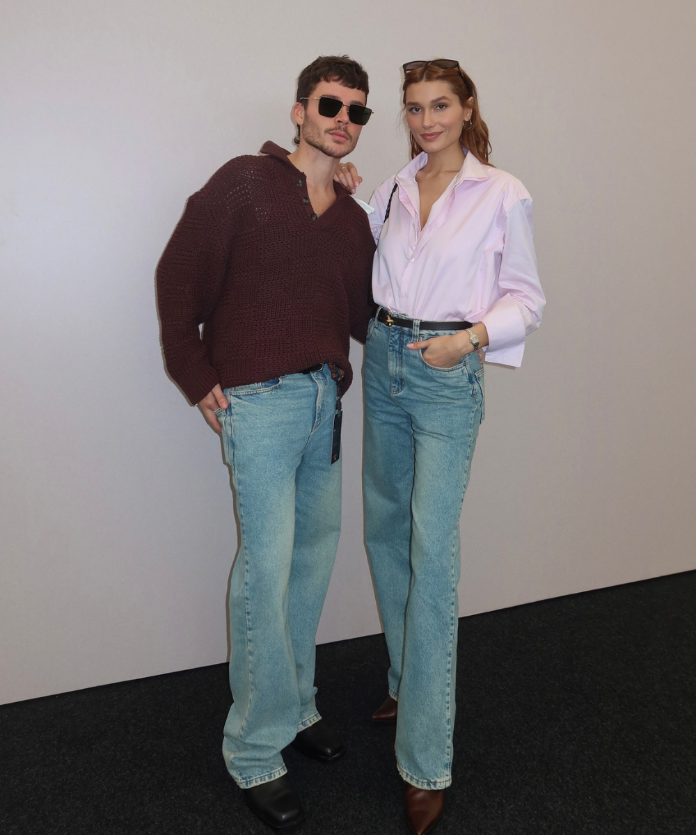 Casal posa casualmente com jeans e camisas, sugerindo tendência de moda moderna. GP de São Paulo 2024.