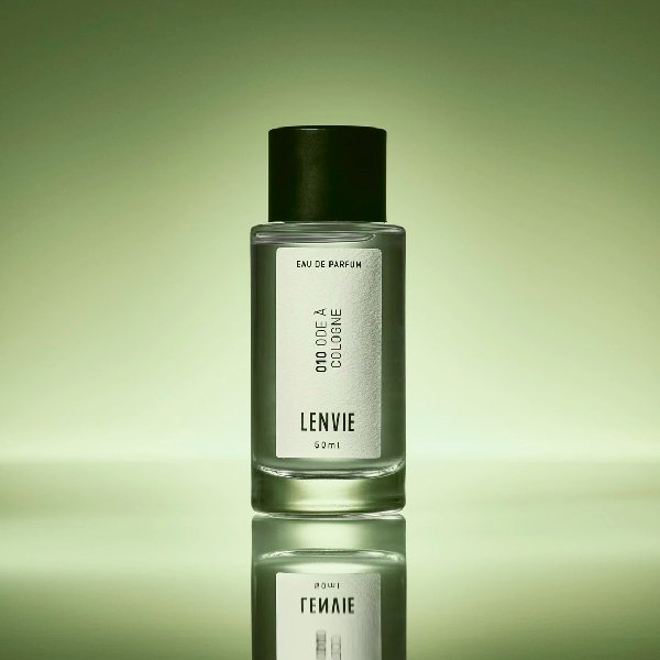 Frasco de perfume Lenvie refletido em superfície, destacando sua coloração e design elegante, relacionado a alternativas para quem não gosta de perfumes doces.