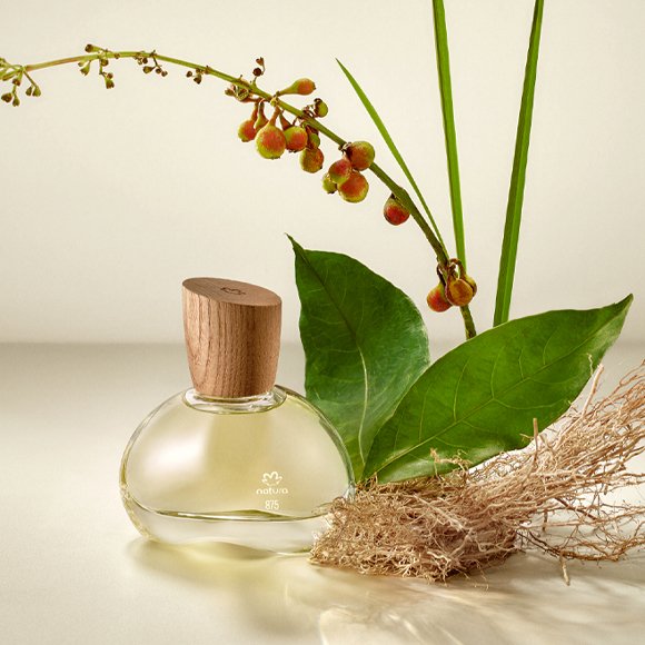 Frasco de perfume com notas doces ao lado de folhas verdes e raízes, transmitindo frescor e naturalidade.  relacionado a alternativas para quem não gosta de perfumes doces.