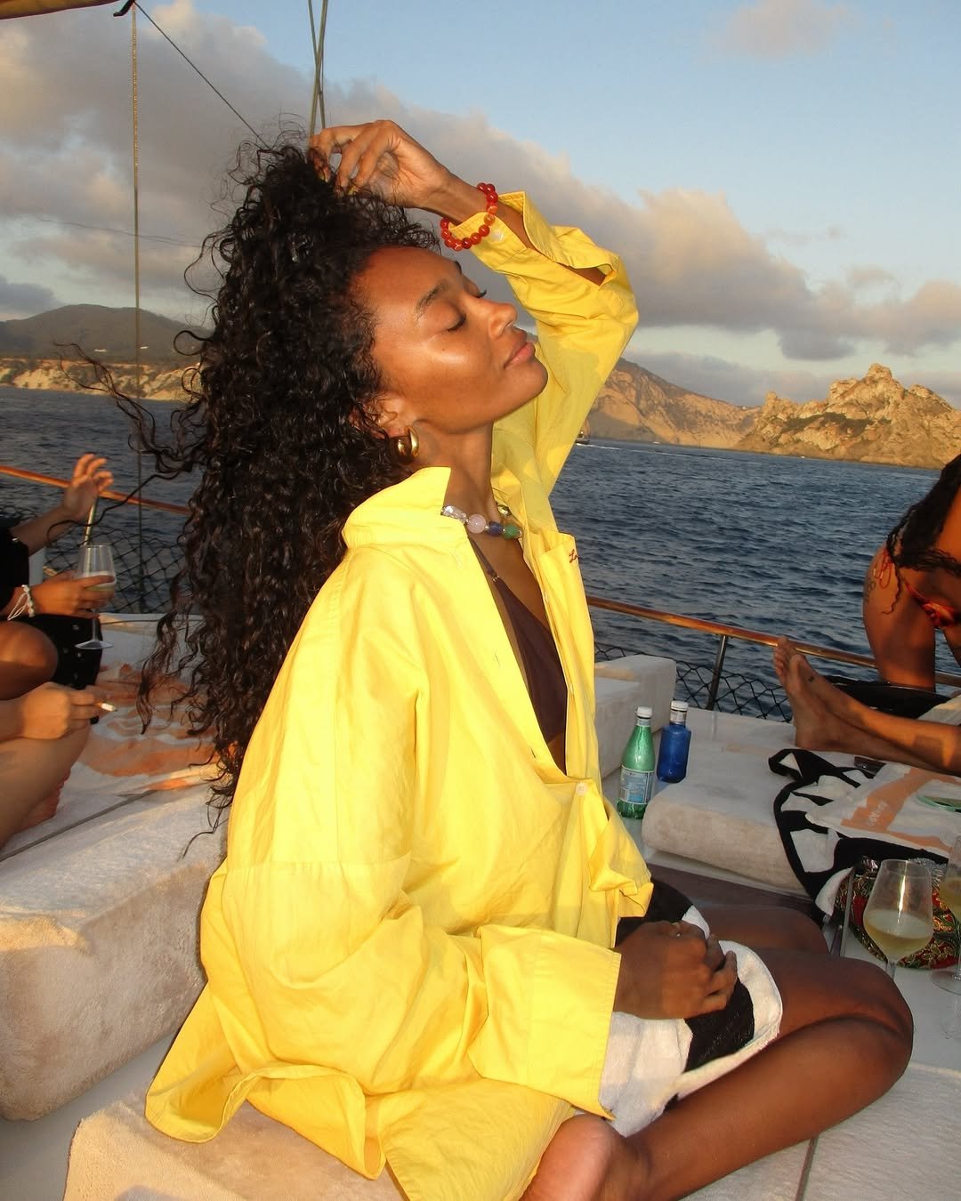 Pessoa em barco ao pôr do sol, usando camisa amarela. bons Protetores solares são importantes para proteção nesse ambiente.