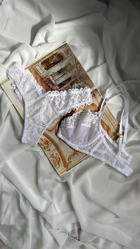 Conjunto de lingerie branca rendada sobre tecido branco, transmitindo elegância e delicadeza. Calcinha de ano novo.