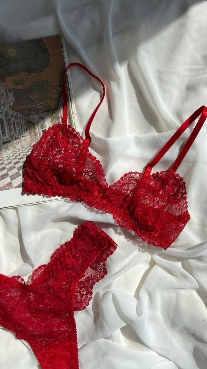 Conjunto de lingerie vermelha rendada sobre tecido branco. Calcinha de ano novo