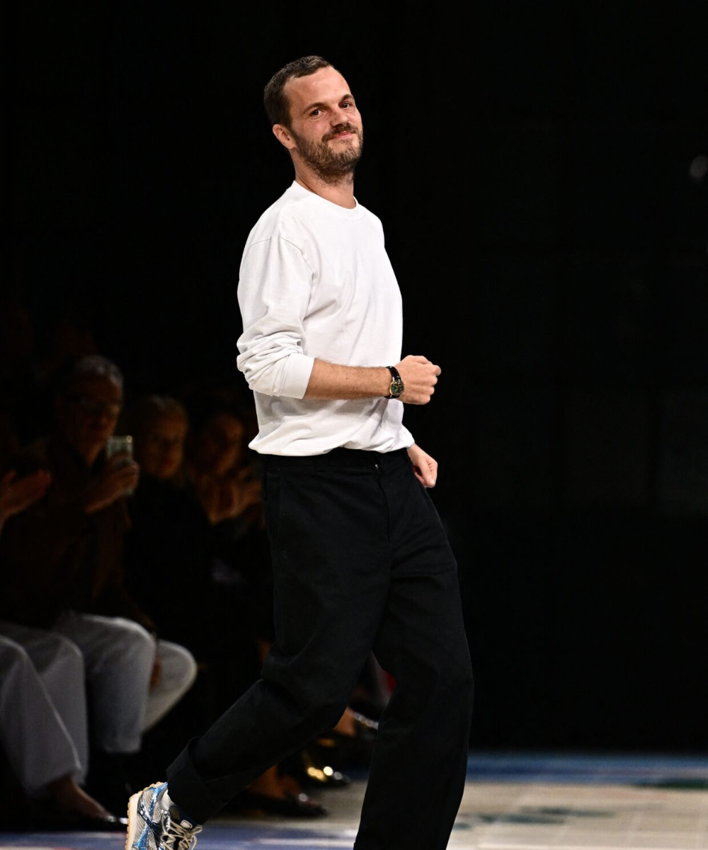 Pessoa sorrindo em desfile de moda, simbolizando a dinâmica da 