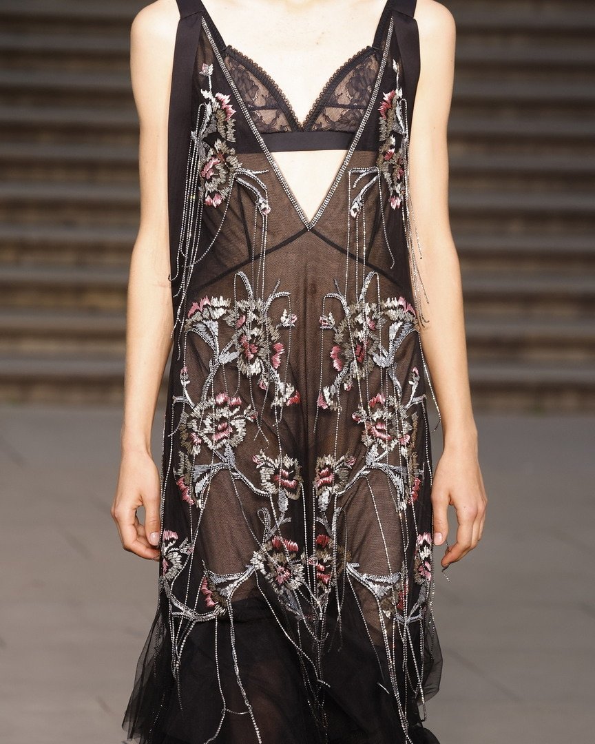 Vestido preto transparente bordado com flores, inspirado na moda dos anos 20.