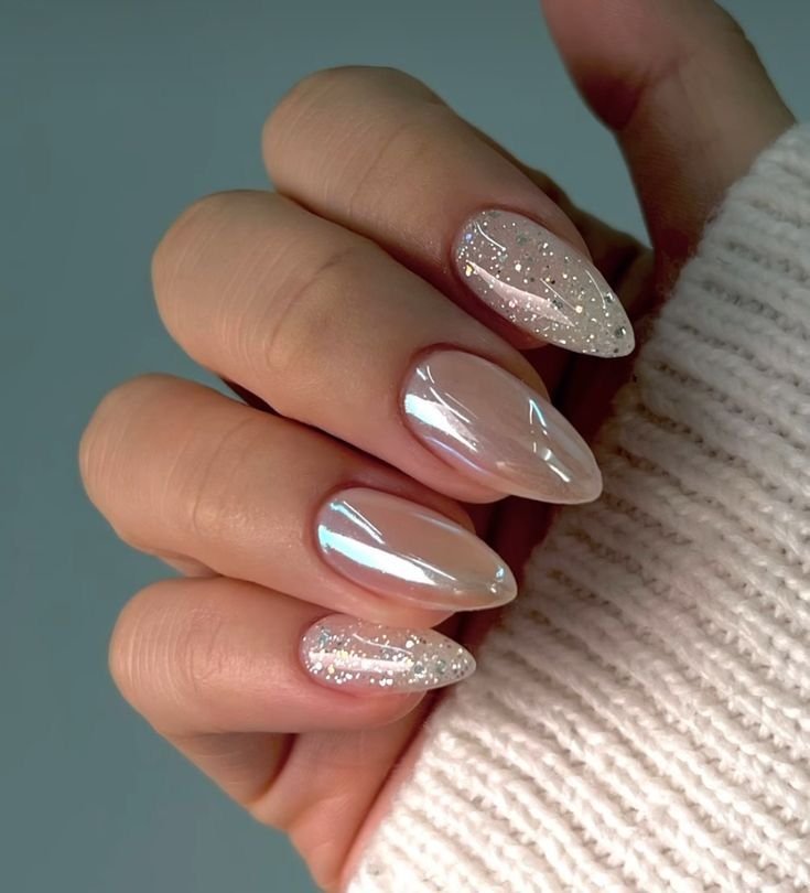 Unhas com esmalte perolado e detalhes de glitter, ideais para a celebração de unhas para ano novo 2025.