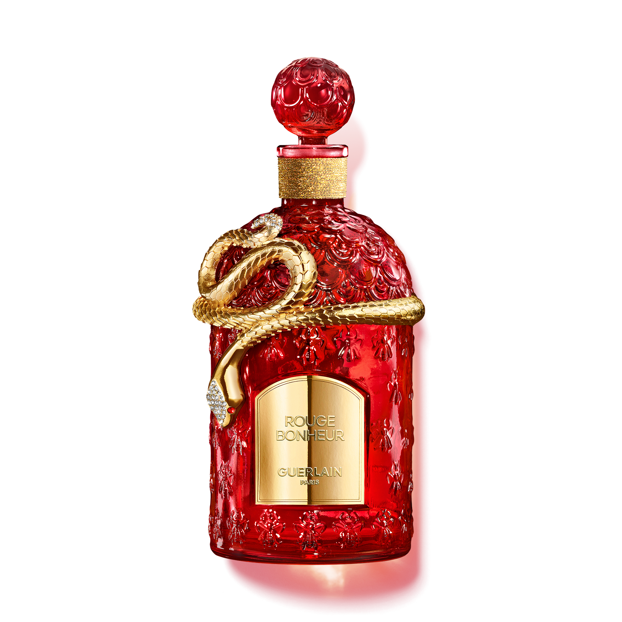 Frasco vermelho de perfume Guerlain decorado com cobra dourada.