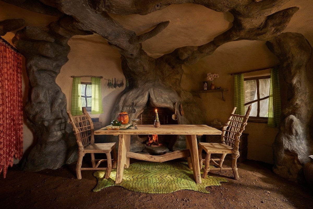 Sala rústica com mesa de madeira cercada por decoração natural, comum em casas temáticas.