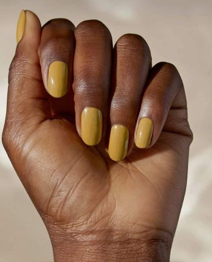 Unhas curtas esmaltadas em amarelo claro, destacando uma opção de cores para unhas curtas. cores de esmaltes para unhas curtas