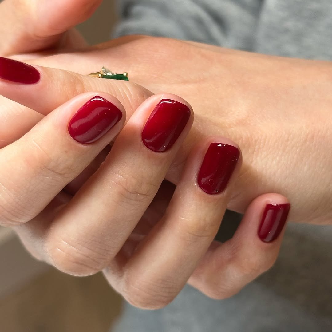 Unhas curtas pintadas com esmalte vermelho brilhante, destacando uma tendência popular de cores para unhas. cores de esmaltes para unhas curtas