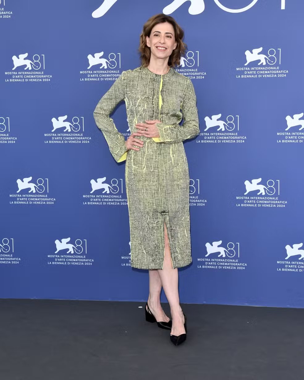 Pessoa usando um vestido elegante verde texturizado, posando em um evento da Bienal de Veneza de 2024. Looks da Fernanda Torres