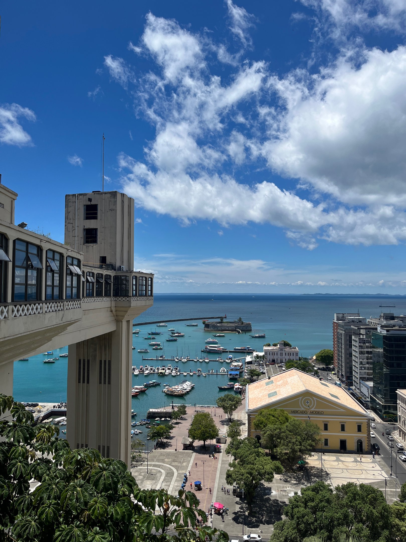 Elevador Lacerda em Salvador com vista para o Mercado Modelo e baía repleta de barcos.