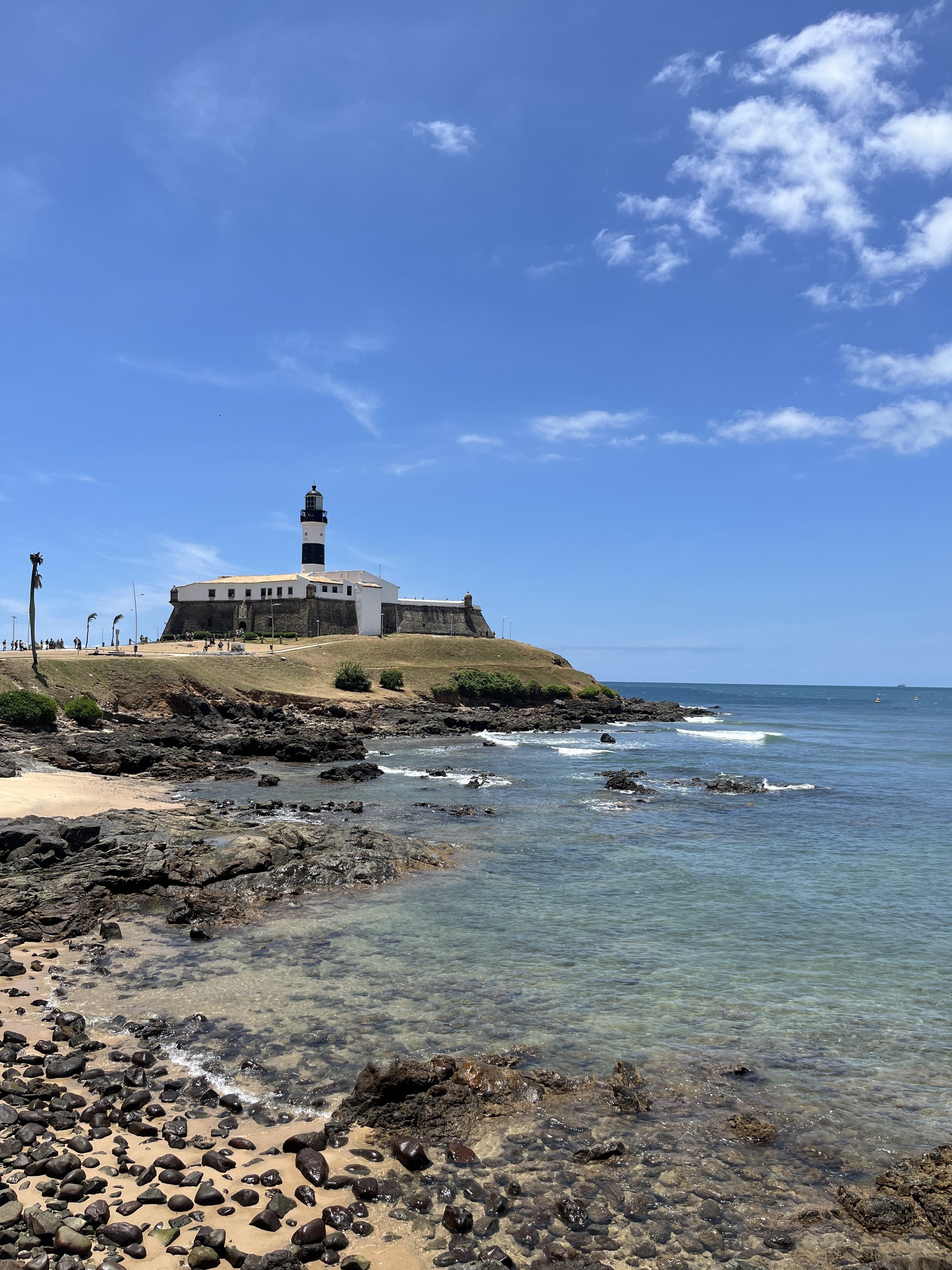 Farol na costa com céu azul e mar, cenário típico para fazer em Salvador.