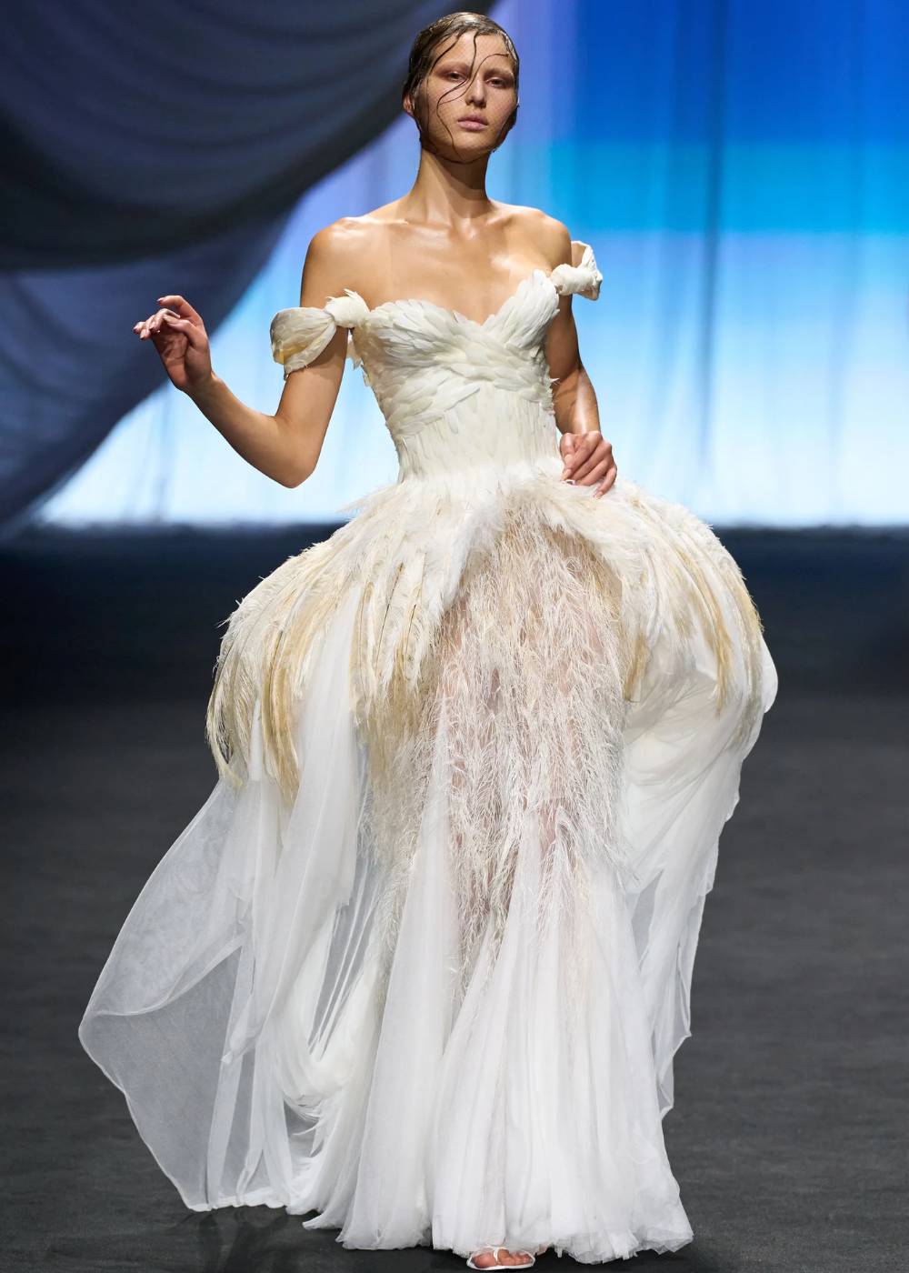 Modelo usa vestido com plumas brancas em desfile de alta-costura. Inefável elegância destaca a Semana de Alta-Costura 2025.