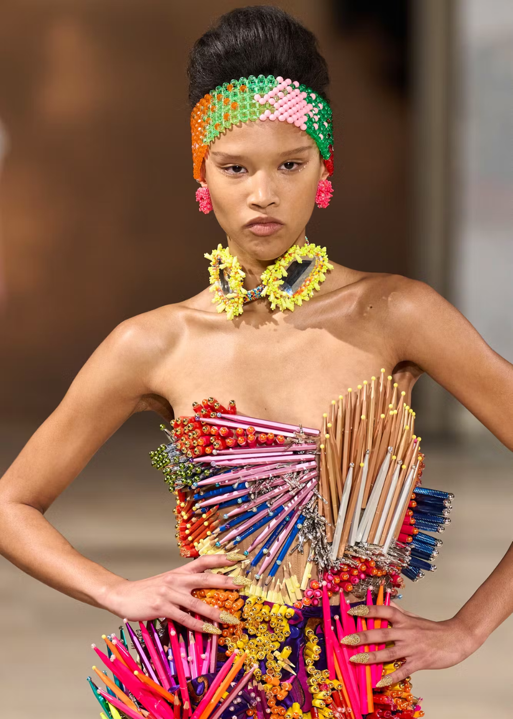 Modelo usa vestido colorido com lápis e miçangas, apresentado na Semana de Alta-Costura 2025.