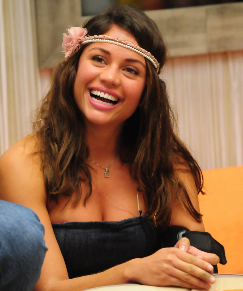 Mulher sorridente com cabelo solto e tiara floral estilo boho, tendência de moda popular no BBB.