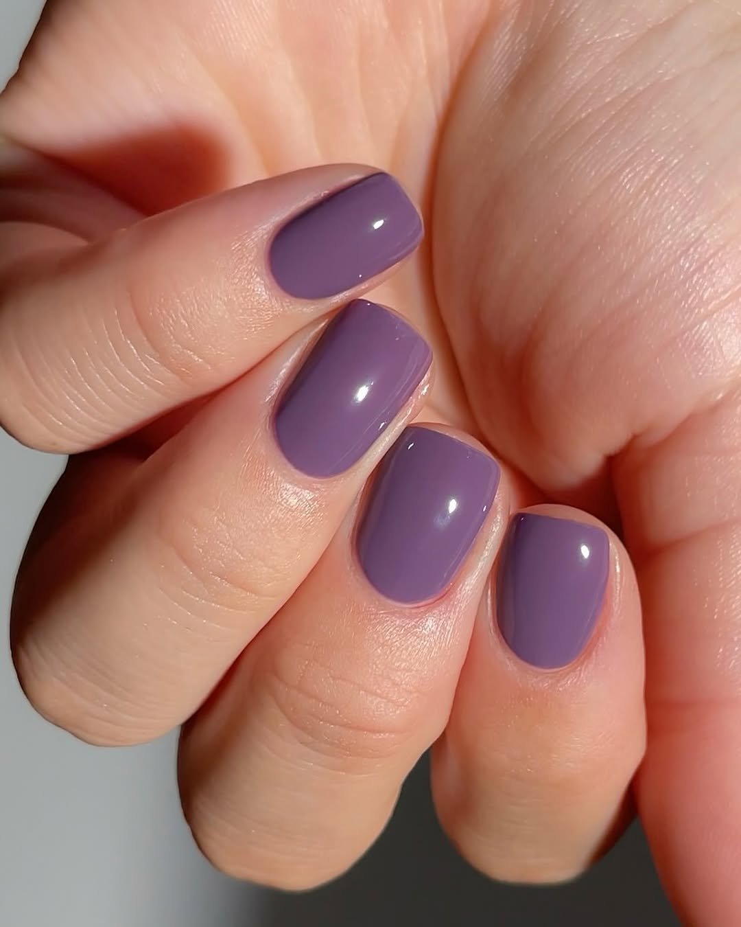Unhas pintadas de lilás com acabamento brilhante, representando um estilo de unhas básicas e elegante.