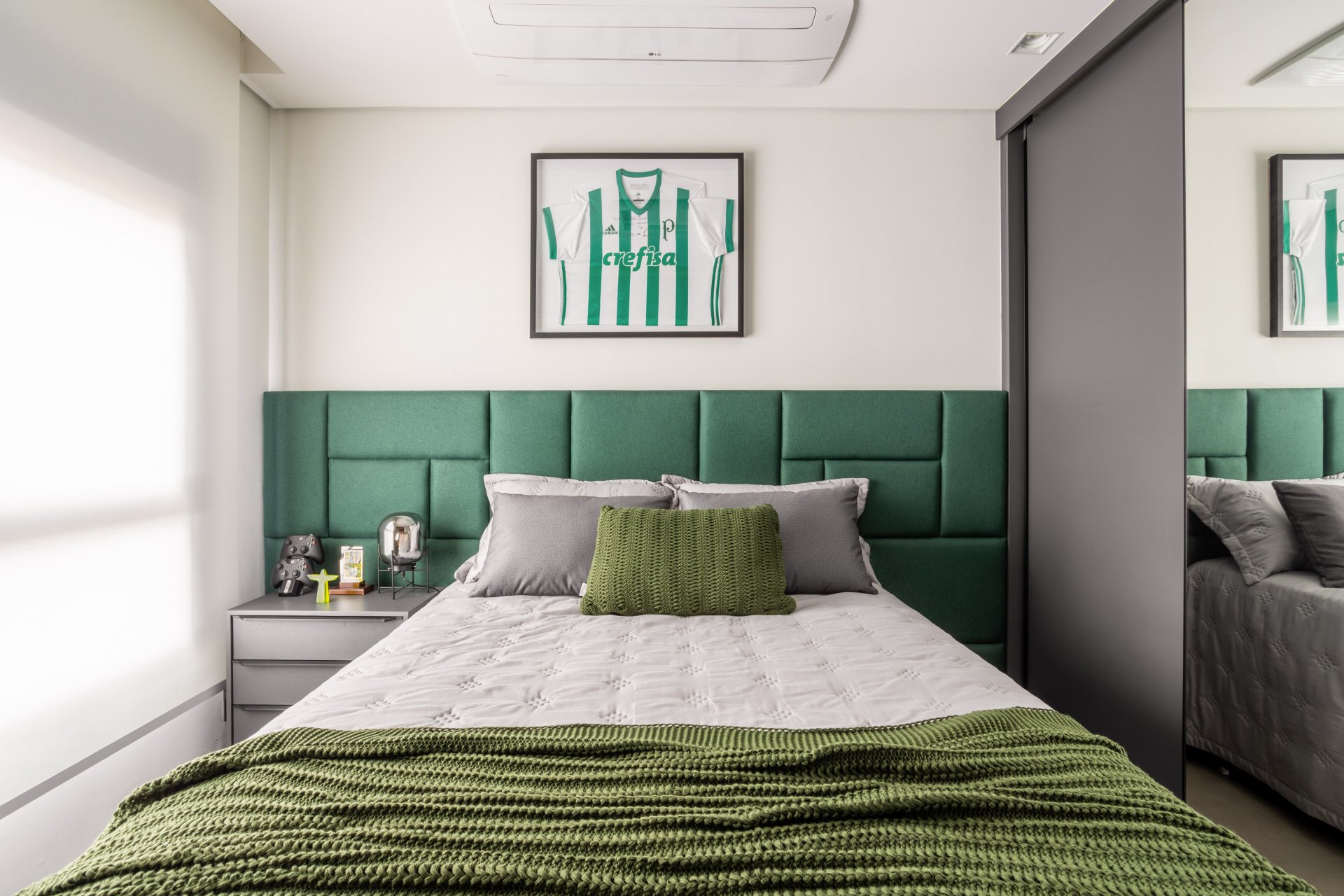 Cama com decoração em verde, incluindo cabeceira e manta. Quadro com camisa de futebol verde na parede. verde na decoração