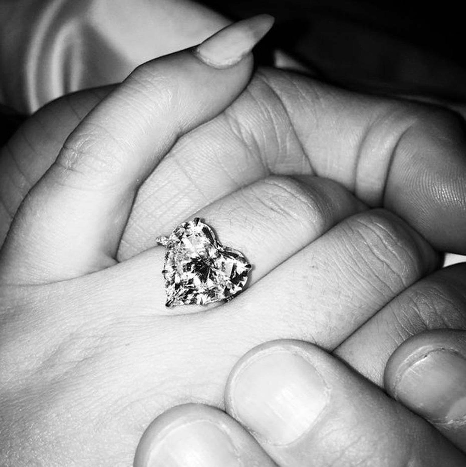 Diamante grande em forma de coração em um anel, representando elegância e possível inspiração em anéis de noivado de celebridades.