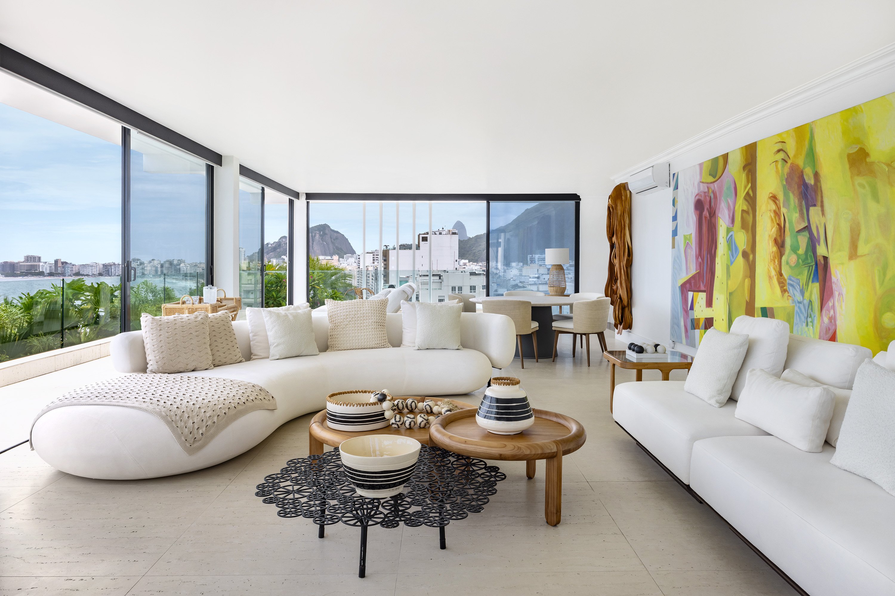 Sala de estar moderna e luminosa com vista para o Rio de Janeiro, destacando decoração minimalista. Carnaval do Rio com Anitta